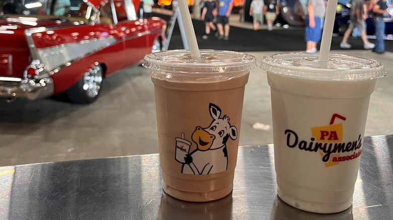 A chocolate and vanilla milkshake sitting on a stainless steel table
