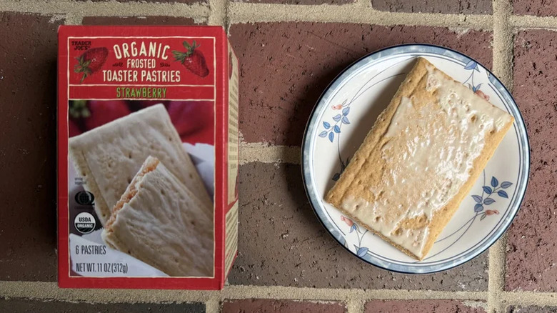 A box of Trader Joe's strawberry toaster pastries next to one pastry laid out on a plate