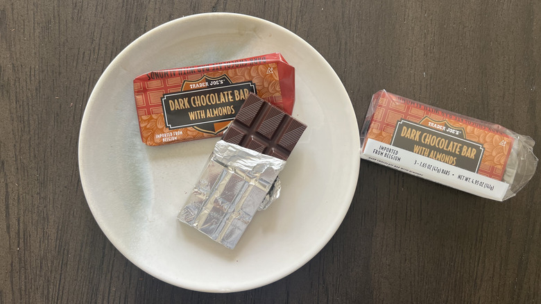 Trader Joe's dark chocolate bar with almonds on a plate with the packaging