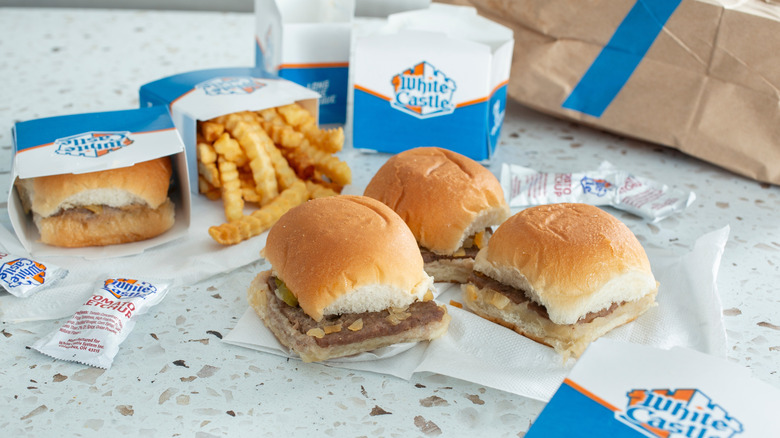 White Castle sliders on a table with sauces and fries