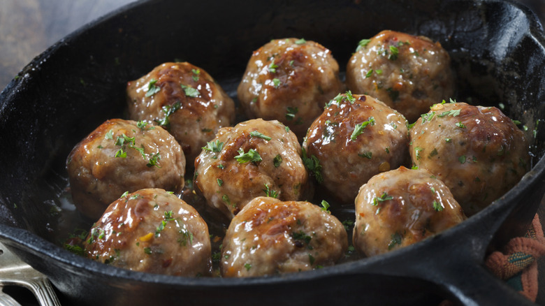 A cast iron skillet full of Meatballs