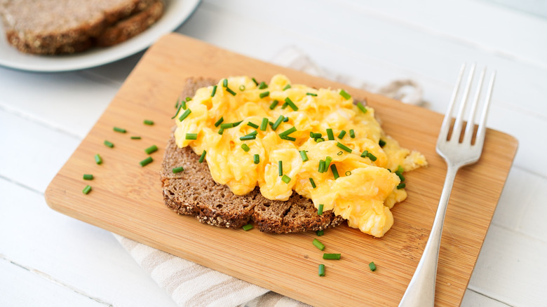 scrambled eggs and chives on top of toast