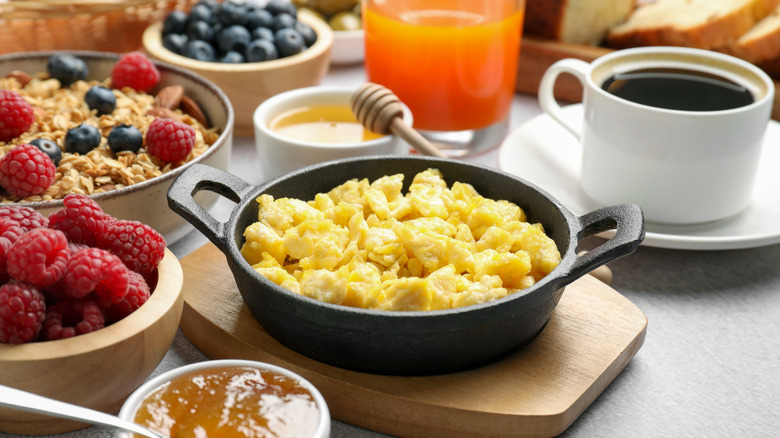 a bountiful breakfast spread with eggs, jams, juice, berries, and coffee