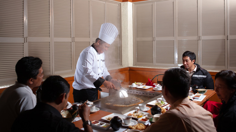 Groups of customers sit around a teppanyaki table