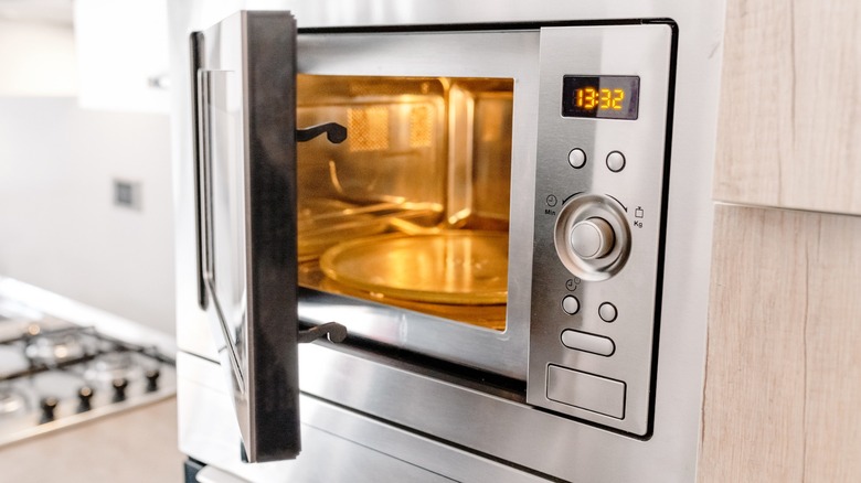 White microwave on a counter next to a stove