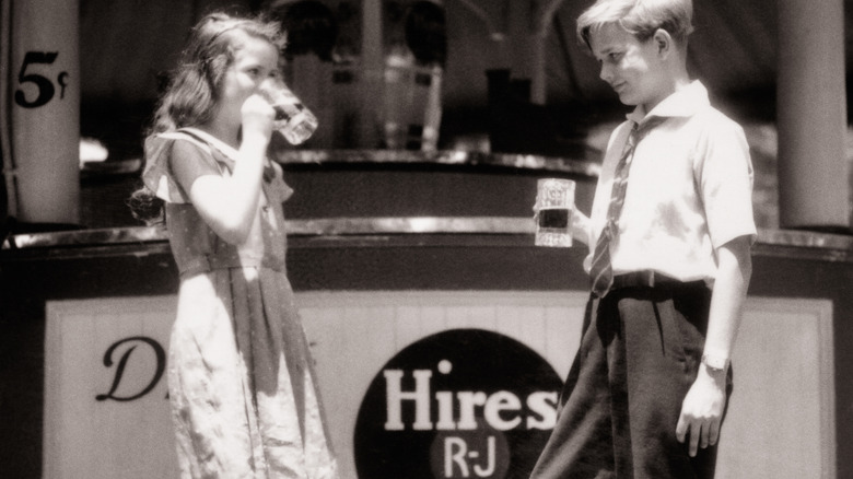 Archival photo of two teens drinking Hires Root Beer
