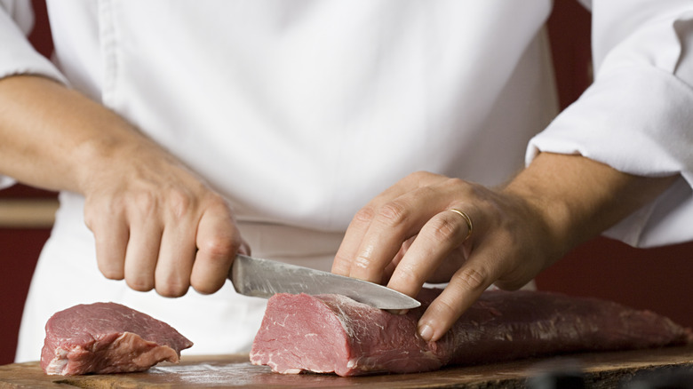 chef cutting pork