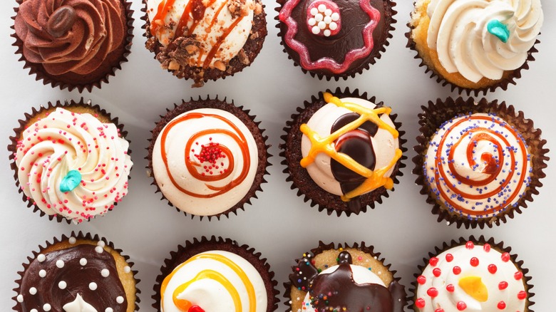 Top-down view of many decorated cupcakes