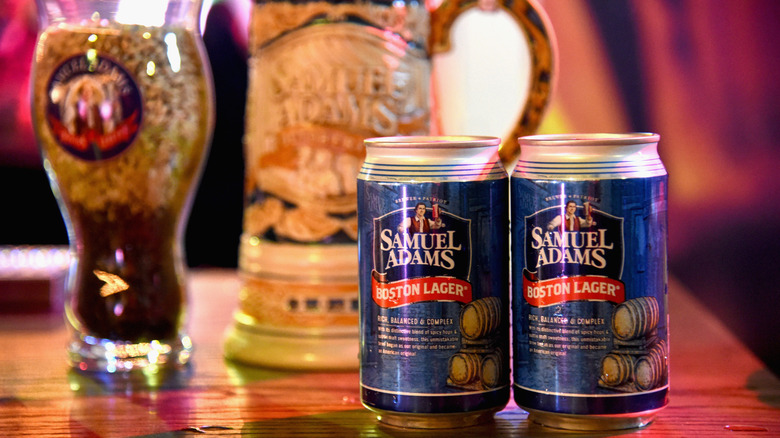 Two cans of Sam Adams with stein and pint glass