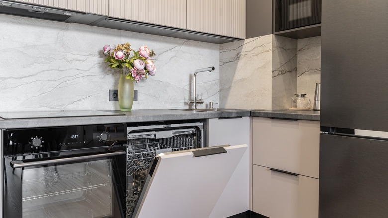 Neutral gray kitchen with marble backsplash and flowers on the countertop