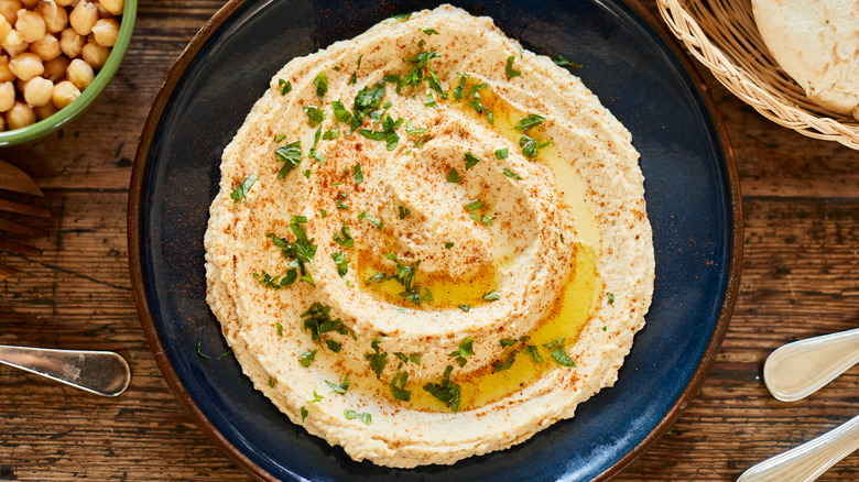 bowl of hummus with olive oil and herbs