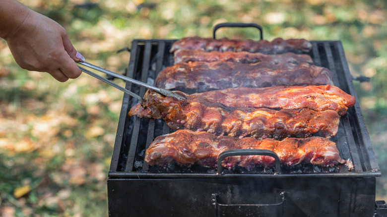 Person smoking several racks of barbecue ribs