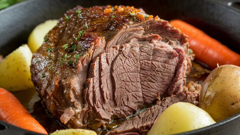 Chuck pot roast surrounded by carrots and potatoes