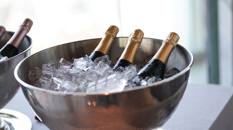 An metallic ice bucket with bottles of Prosecco