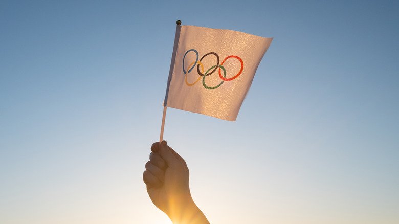hand holding small olympic flag