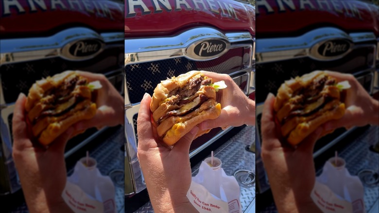 Someone eating the firefighter-style In-N-Out burger hack from social media