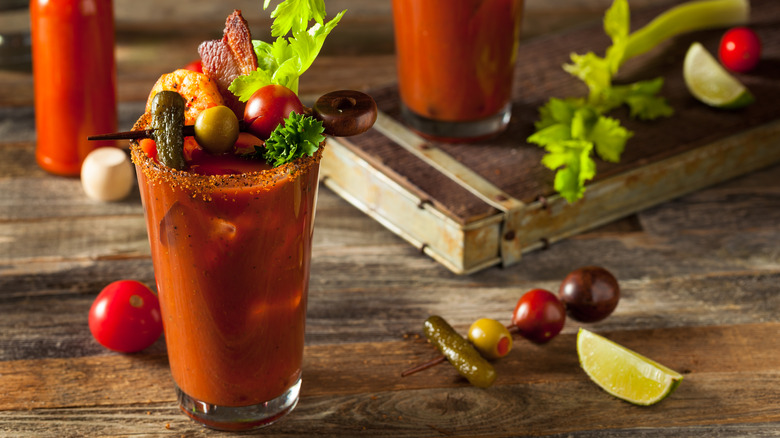 Bloody Mary on wooden table with vegetable garnishes