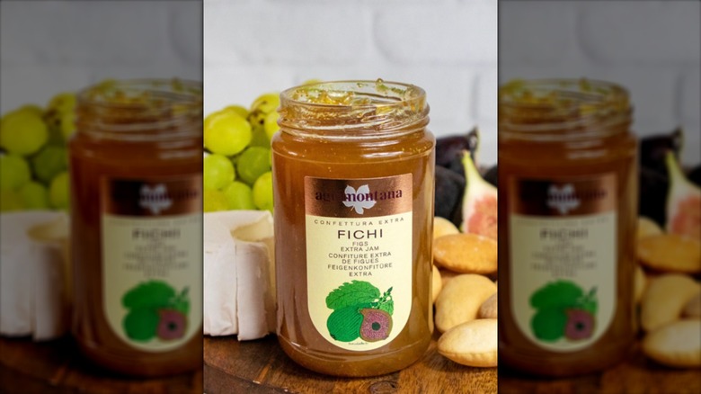 A jar of Agrimontana's white fig jam on a plate with pieces of fig and other fruits