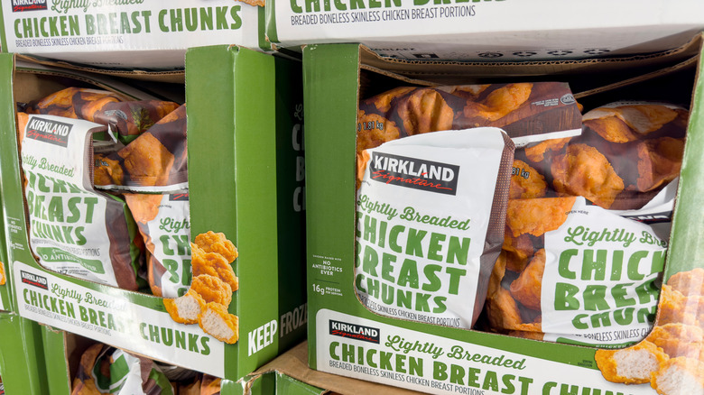 Packages of Kirkland Signature Lightly Breaded Chicken Breast Chunks in the store's freezer section