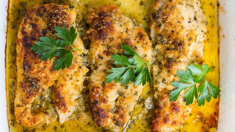close up of baked parmesan chicken with herbs