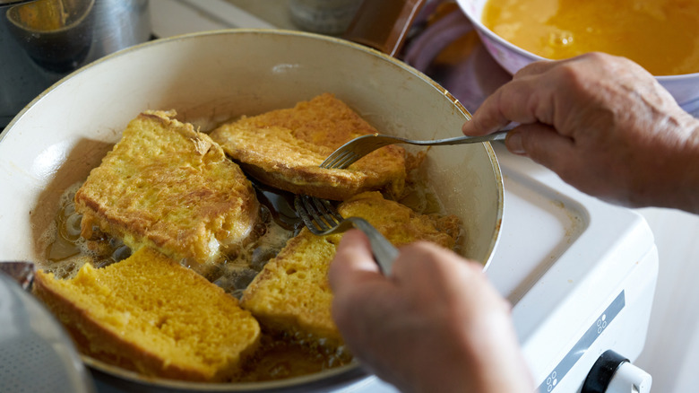 woman frying French toast in a skillet
