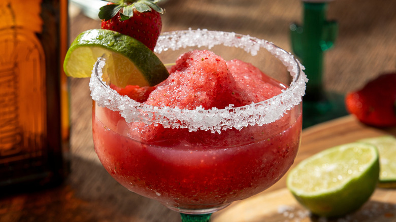 A frozen strawberry margarita with a salt rim