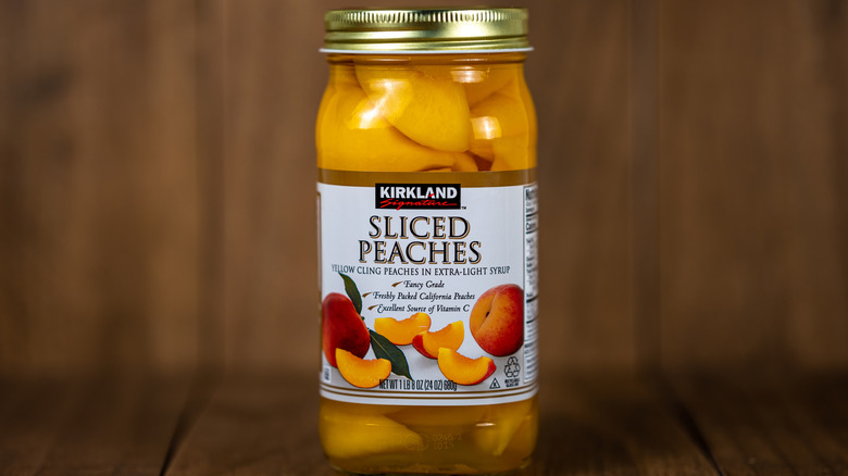 Jar of Costco Kirkland Signature Sliced Peaches on wooden surface