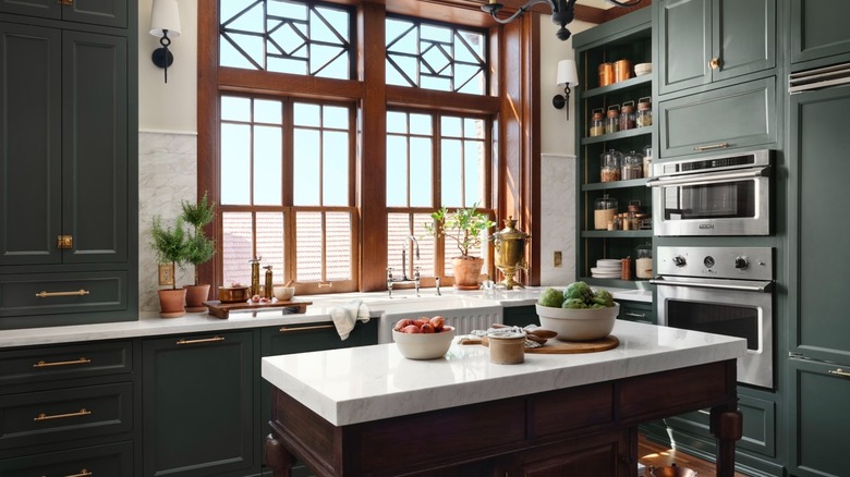 Kitchen with Castle Cream walls, Cottage Grove cabinetry, white countertops, and dark wood accents