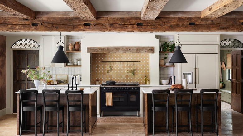 Farmhouse kitchen with creamy white walls and countertops with wood cabinets and ceiling beams