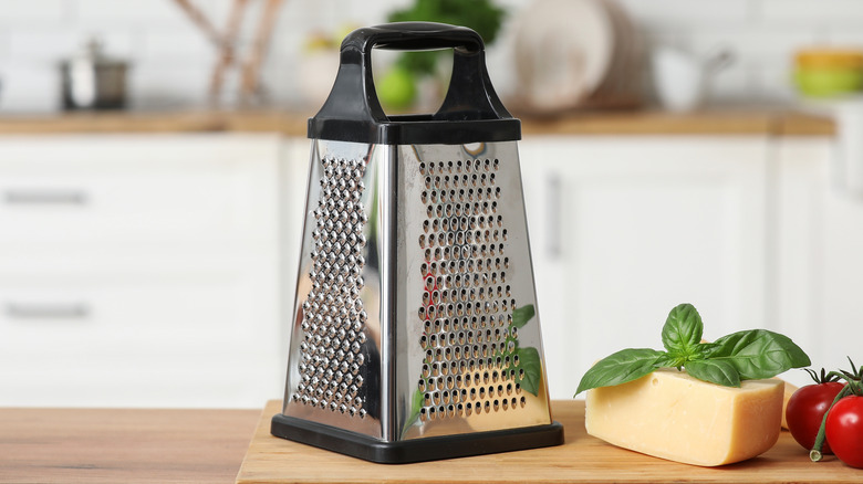 Grater on cutting board with cheese