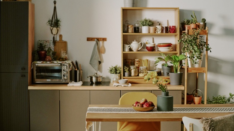 View of kitchen with counters full of bowls, pans, and flower pots