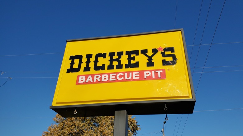 a yellow dickey's barbecue pit sign