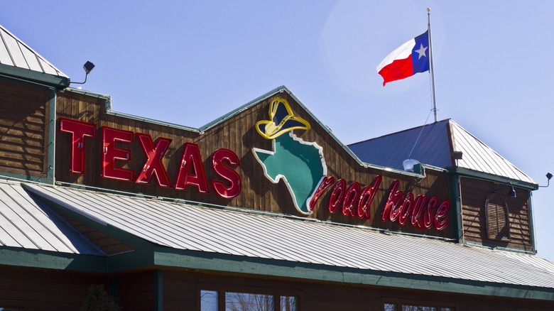 Texas Roadhouse storefront with sign and Texas flag