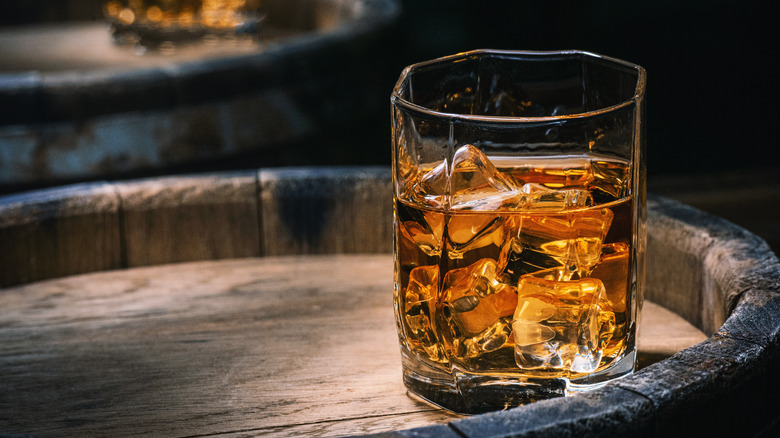 bourbon in glass on barrel