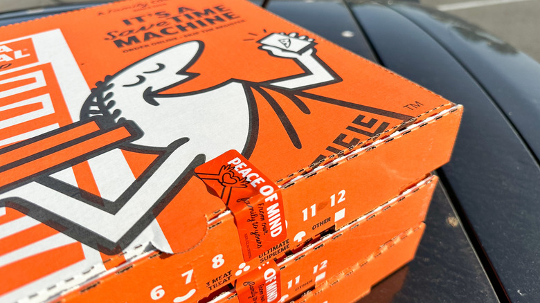 Boxes of Little Caesars pizza outside.