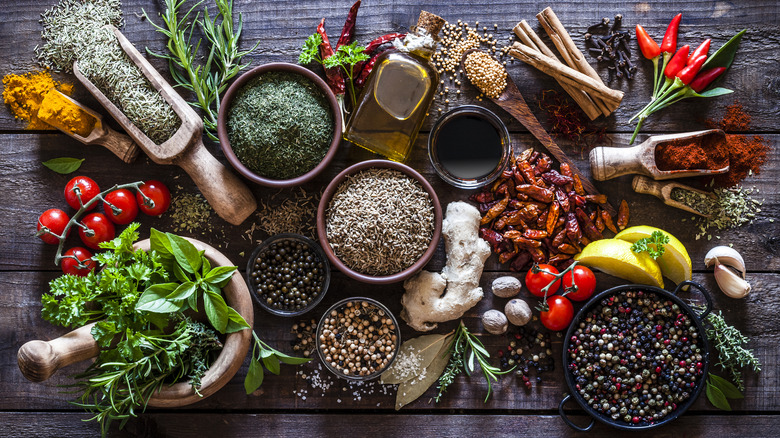 a wooden table filled with an artfully arrayed selection of herbs and spices
