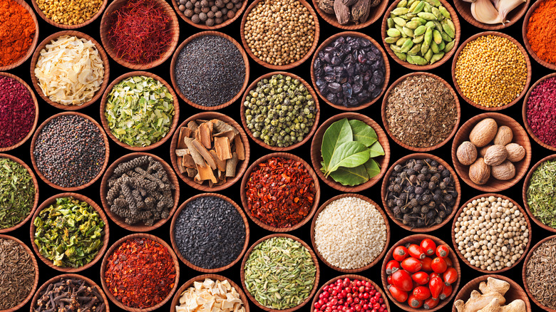 many small dishes of herbs and spices