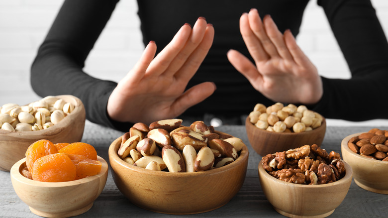 Woman refusing bowls of nuts due to allergy