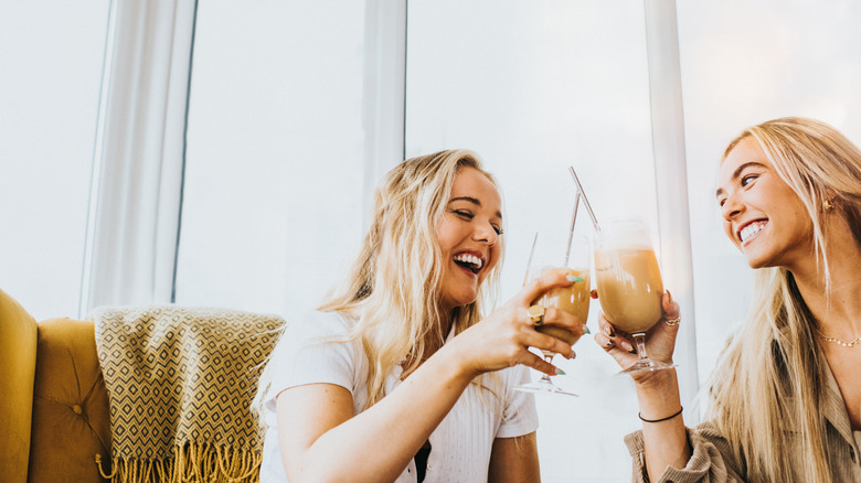 women drinking iced coffee beverages