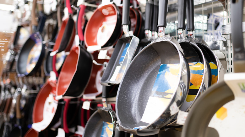 Frying pans hung on racks of a store