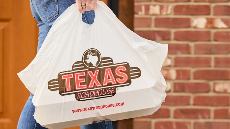 Unidentified person carrying Texas Roadhouse to-go bag