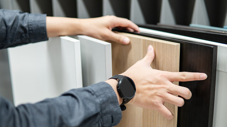 person looking at different kitchen cabinet materials in a store