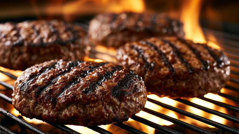 Beef burger patties searing  on a grill