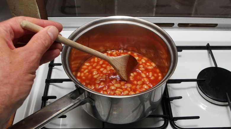 person stirring beans in pot