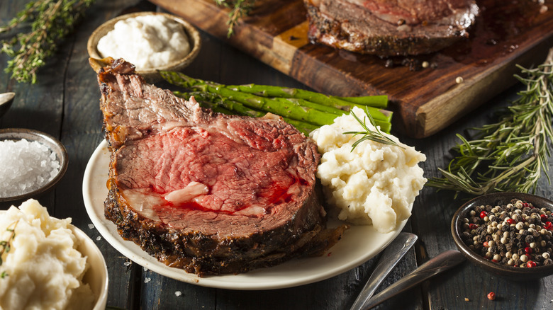 A plate of prime rib and vegetables