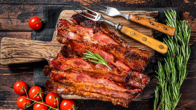 bacon on wooden board with tomatoes