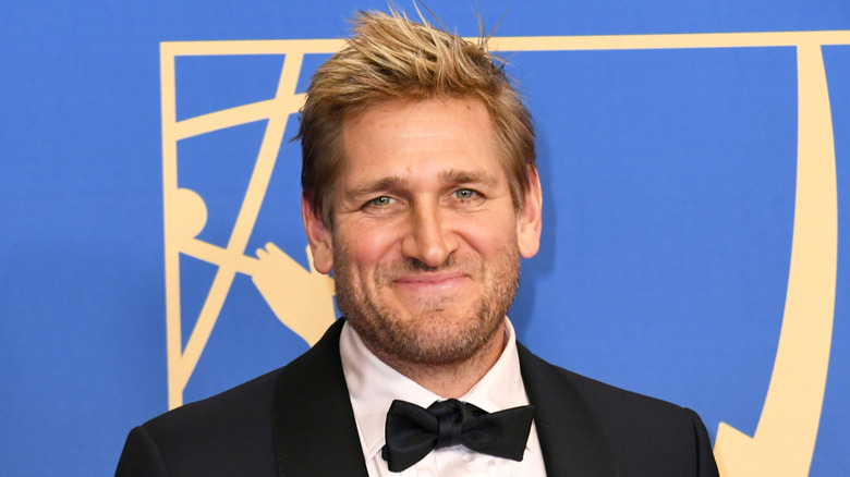 Chef Curtis Stone, smiling against blue background