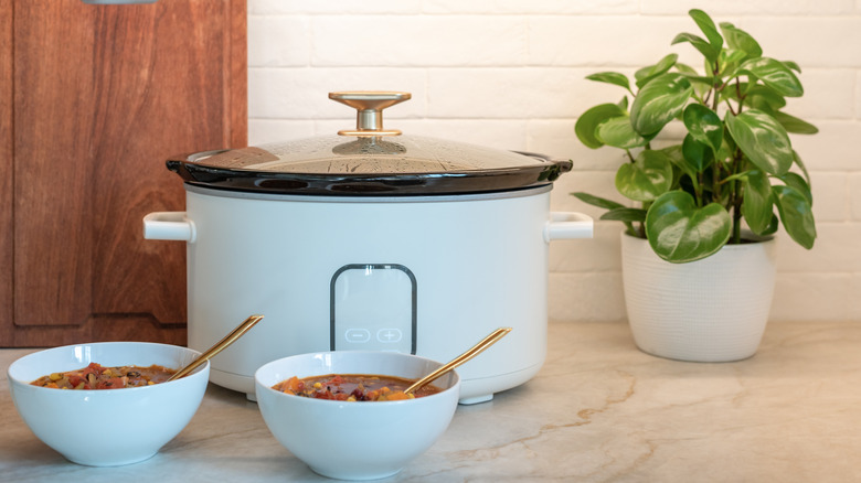 Slow cooker and bowls of chili