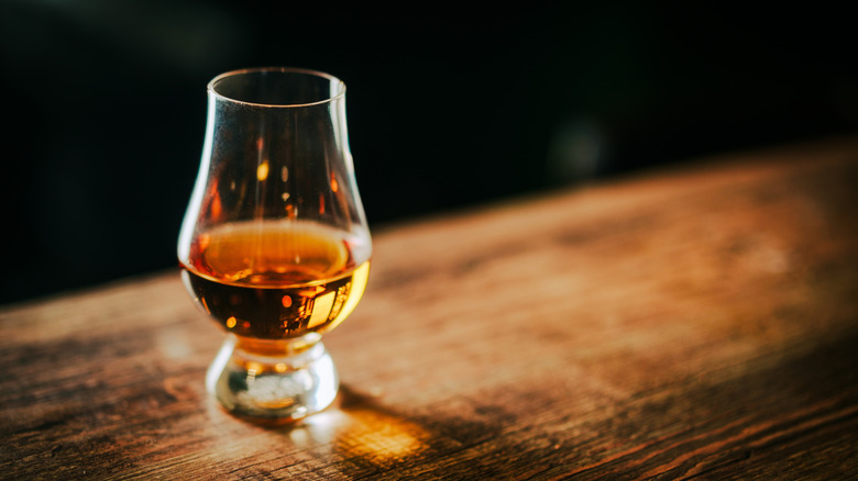 Whisky glencairn glass on table.