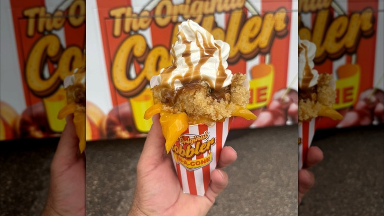 A person holding Peach Cobbler in a Cone dessert.